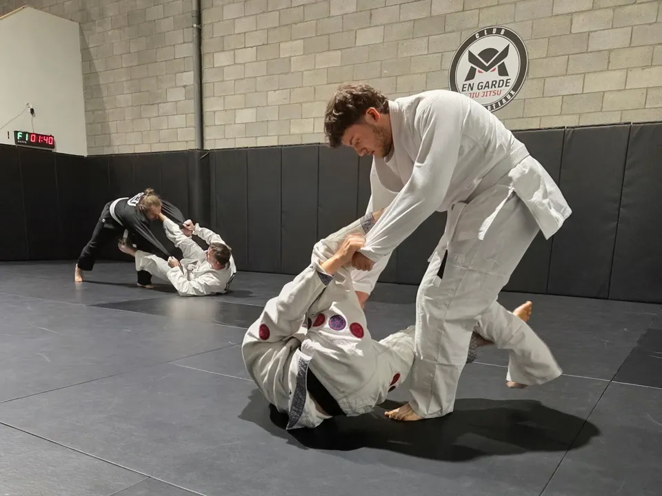 Pratiquants en plein randori de jiu-jitsu brésilien sur le tatami du club En Garde